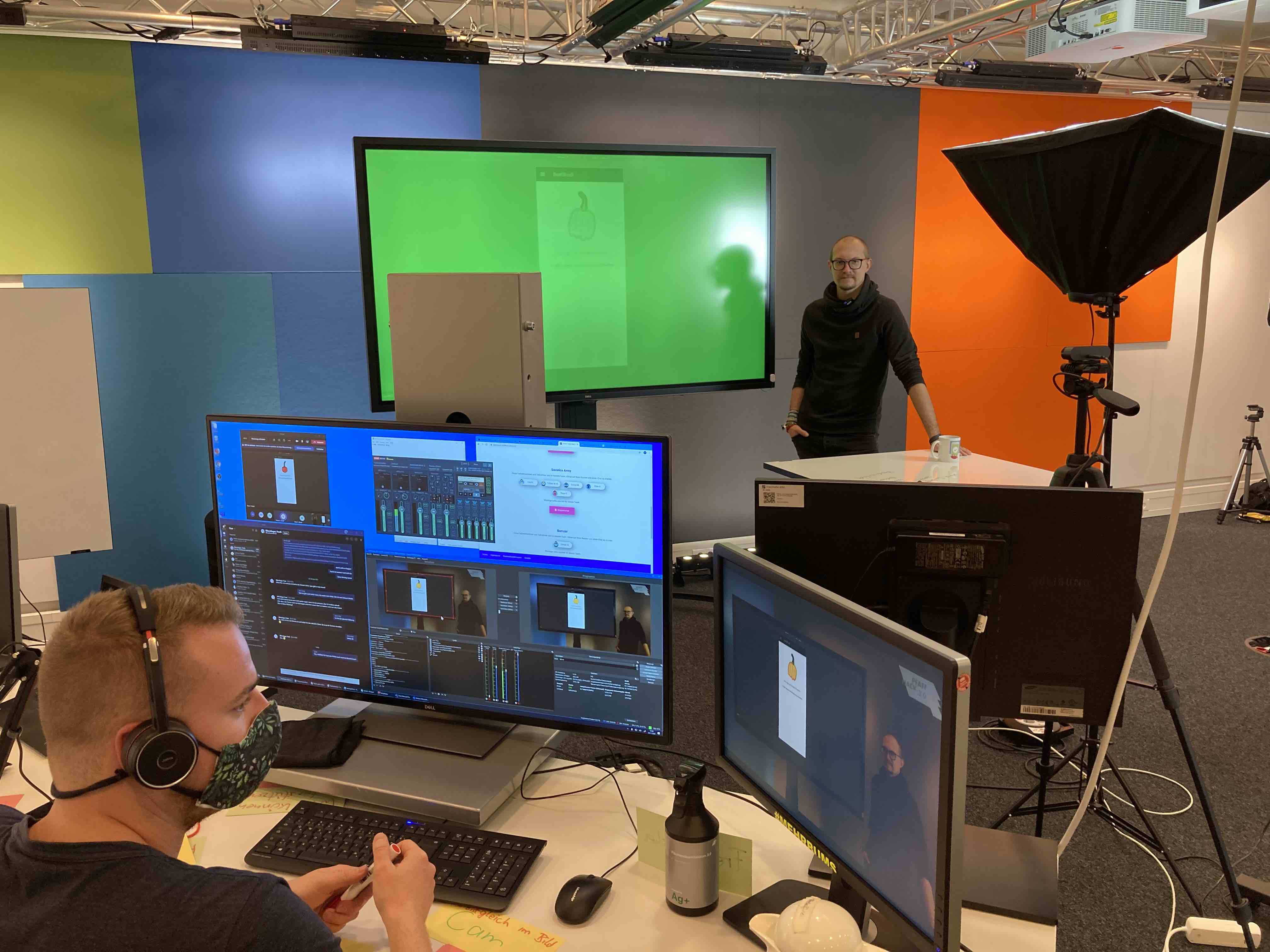 Ein Studio mit einem PC und einem großen Bildschirm mit grünem Hintergrund